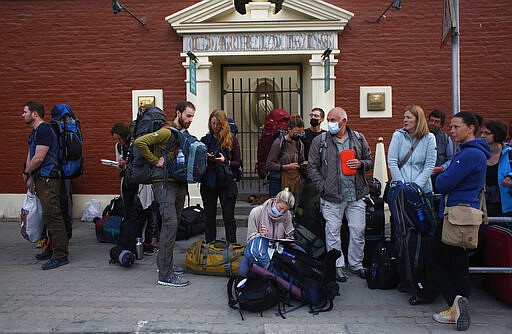 Stranded German tourists wait for a bus to take them to the airport in Kathmandu, Nepal, Friday, March 27, 2020. A rescue flight arranged by the German government on Friday picked up tourists who had been stranded in Nepal since the Himalayan nation went on lockdown earlier this week, officials said. The airport reopened only for the flight, which did not bring any passengers to Nepal. Up to 10,000 tourists are believed to be stranded in Nepal since the government ordered a complete lockdown that halted all flights and road travel to prevent the spread of the virus. (AP Photo/Niranjan Shrestha)