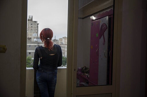 In this Oct. 28, 2019 photo, transgender woman Malak el-Kashif stands on her balcony as the sun sets, in Cairo, Egypt. Years of asking Who am I? &quot;This was the hardest phase ever, even harder than confronting society, harder than prison,&quot; she said. &quot;It was a huge fight that no one could protect me from.&quot; (AP Photo/Nariman El-Mofty)