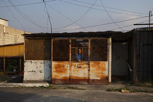 A resident looks out from his home during a stay-at-home order across the country to help prevent the spread of the new coronavirus, at La Chacra neighborhood in Guatemala City, Friday, March 27, 2020. (AP Photo/Moises Castillo)