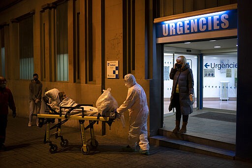 An elderly COVID-19 patient is transferred to an ambulance from a Hospital in Barcelona, Spain, Friday, March 27, 2020. The new coronavirus causes mild or moderate symptoms for most people, but for some, especially older adults and people with existing health problems, it can cause more severe illness or death. (AP Photo/Felipe Dana)