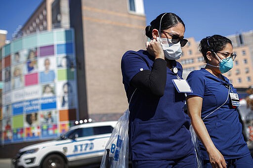 Nurses leave Elmhurst Hospital Center where COVID-19 testing continues outside, Friday, March 27, 2020, in New York. The new coronavirus causes mild or moderate symptoms for most people, but for some, especially older adults and people with existing health problems, it can cause more severe illness or death. (AP Photo/John Minchillo)