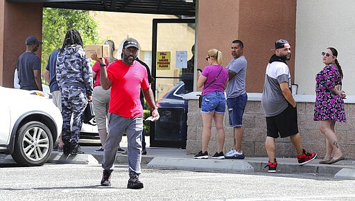 A gun owner leaves the Shoot Straight gun store in Casselberry, Fla., Sunday, March 22, 2020. Gun sales have increased nationwide in response to the coronavirus pandemic. (Joe Burbank/Orlando Sentinel via AP)