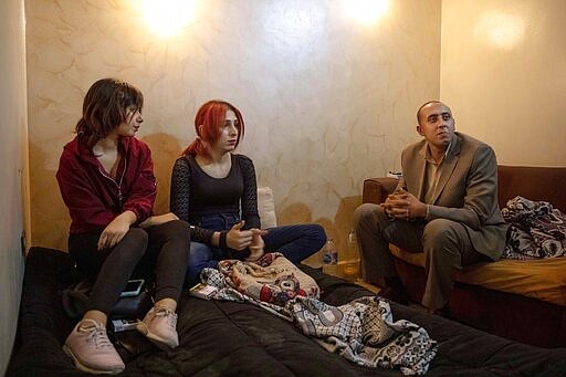 In this Oct. 28, 2019 photo, activist and transgender woman Malak el-Kashif, center, sits with her lawyer and friend at her apartment in Cairo, Egypt. El-Kashif said she never received a response to her case. She was diagnosed with &quot;gender identity disorder,&quot; she said. The term was replaced in the American Psychiatric Association's diagnostic guide by &quot;gender dysphoria&quot;-- a disconnect between assigned gender at birth and the one a person identifies with, which may lead to significant distress. (AP Photo/Nariman El-Mofty)