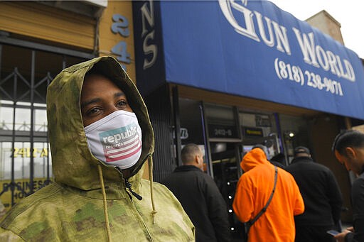 A gun store customer that gave his name only at John waits in line, Sunday, March 15, 2020, in Burbank, Calif. As consumers are buying all kinds of goods in large quantities amid coronavirus concerns, putting pressure on inventories, John stated that he was there to buy ammunition because most other stores were out and he wanted to stock up. (AP Photo/Mark J. Terrill)