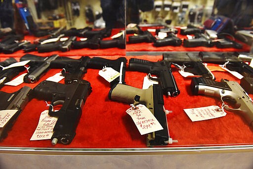 Handguns sit in a display case at Nimrod Haven Hunting &amp; Fishing in Hanover Township near Wilkes-Barre, Pa., Wednesday, March 18, 2020. Pennsylvania's state-run background check system for gun purchases processed more than 4,300 transactions on Tuesday, about three times its typical daily rate. State police said Wednesday the numbers were high even though the system had two computer outages of more than three hours apiece on Tuesday. (Sean McKeag/The Citizens' Voice via AP)