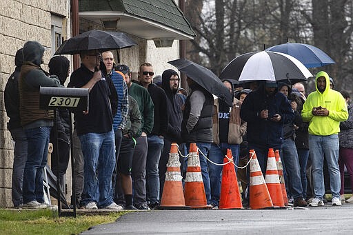 People wait in line to enter gun seller Tanner's Sports Center in Jamison, Pa., Tuesday, March 17, 2020. Pennsylvania's state-run background check system for gun purchases processed about three times its typical daily rate on Tuesday, as guns and ammunition have been flying off store shelves nationwide. (AP Photo/Matt Rourke)