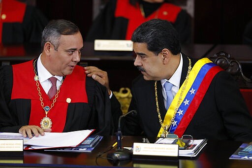 FILE - In this Jan. 31, 2020 file photo, Venezuelan President Nicolas Maduro, right, speaks with Supreme Court President Maikel Moreno at the Supreme Court in Caracas, Venezuela. Maduro is at the court to give his annual presidential address.  On Thursday, March 26, 2020, the U.S. Justice Department made public it has charged in several indictments against Maduro and his inner circle, including Moreno, that the leader has effectively converted Venezuela into a criminal enterprise at the service of drug traffickers and terrorist groups as he and his allies stole billions from the South American country. (AP Photo/Ariana Cubillos, File)