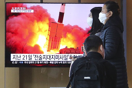 People pass by a TV screen showing a file image of North Korea's missile launch during a news program at the Seoul Railway Station in Seoul, South Korea, Sunday, March 29, 2020. North Korea on Sunday fired two suspected ballistic missiles into the sea, South Korea said, calling it &quot;very inappropriate&quot; at a time when the world is battling the coronavirus pandemic. The Korean letters read: &quot;March 21, Tactical Missile.&quot; (AP Photo/Ahn Young-joon)