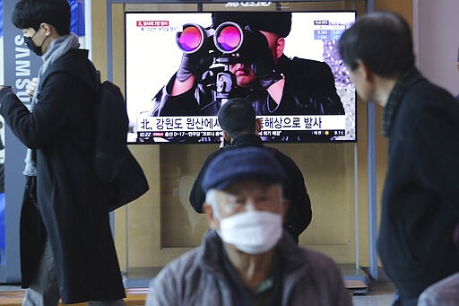 People pass by a TV screen showing a file image of North Korean leader Kim Jong Un during a news program at the Seoul Railway Station in Seoul, South Korea, Sunday, March 29, 2020. North Korea on Sunday fired two suspected ballistic missiles into the sea, South Korea said, calling it &quot;very inappropriate&quot; at a time when the world is battling the coronavirus pandemic. The Korean letters read: &quot; North Korea launched two suspected ballistic missiles into the sea.&quot; (AP Photo/Ahn Young-joon)