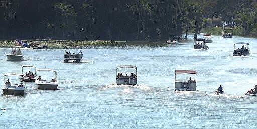 Boaters travel along the Dead River in Tavares, Fla., on Saturday, March 28, 2020. The waterway connects Lake Harris and Lake Eustis, and is a popular spot for people to practice &quot;social distancing&quot; on the water during the coronavirus outbreak. (Stephen M. Dowell/Orlando Sentinel via AP)