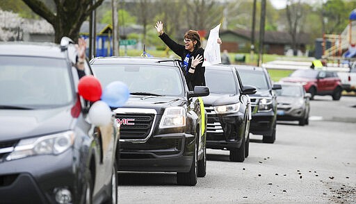 Austinville Elementary School teachers in Decatur, Ala., drive Wednesday, March 25, 2020 through the neighborhoods where their students live in Decatur, Ala. to show them their love and encourage them to keep studying, reading and learning while the school is closed due to the coronavirus pandemic. (Jeronimo Nisa/The Decatur Daily via AP)