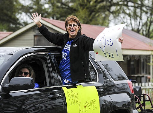 Austinville Elementary School teachers in Decatur, Ala., drive Wednesday, March 25, 2020 through the neighborhoods where their students live in Decatur, Ala. to show them their love and encourage them to keep studying, reading and learning while the school is closed due to the coronavirus pandemic. (Jeronimo Nisa/The Decatur Daily via AP)