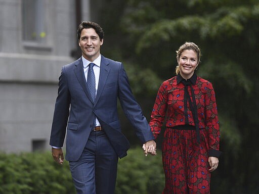 In this Wednesday, Sept. 11, 2019 photo, Canada's Prime Minister Justin Trudeau and his wife Sophie Gregoire Trudeau arrive at Rideau Hall in Ottawa, Ontario. Trudeau is quarantining himself at home after his wife exhibited flu-like symptoms. Trudeau's office said Thursday, March 12, 2020, that Sophie Gr&eacute;goire Trudeau returned from a speaking engagement in Britain and had mild flu-like symptoms, including a low fever late, Wednesday night.  (Justin Tang/The Canadian Press via AP)