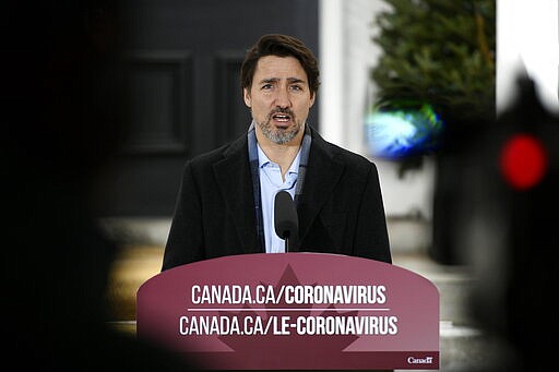 Prime Minister Justin Trudeau speaks during his daily press conference on COVID-19, in front of his residence at Rideau Cottage, on the grounds of Rideau Hall in Ottawa, on Saturday, March 28, 2020.  (Justin Tang/The Canadian Press via AP)