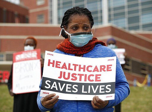 Rehabilitation nurse Edith Ihejirika holds a sign as she participates in a demonstration outside the emergency entrance to Jacobi Medical Center in the Bronx borough of New York, Saturday, March 28, 2020. Nurses at the hospital demonstrated demanding adequate Personal Protective Equipment after Mount Sinai West emergency room nurse Kious Kelly, died Tuesday, after a 10-day bout with the disease. New York has the most cases of the virus in the world, according to the World Health Organization. (AP Photo/Kathy Willens)