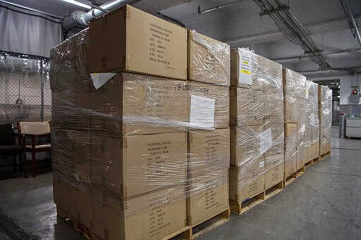 In this March 28, 2020 photo provided by the United Nations, pallets containing 250,000 face masks rest on a landing dock at United Nations headquarters. On Saturday, New York Mayor Bill de Blasio accepted the masks from the U.N. for use in the city's battle against the coronavirus. (Eskinder Debebe/The United Nations via AP)