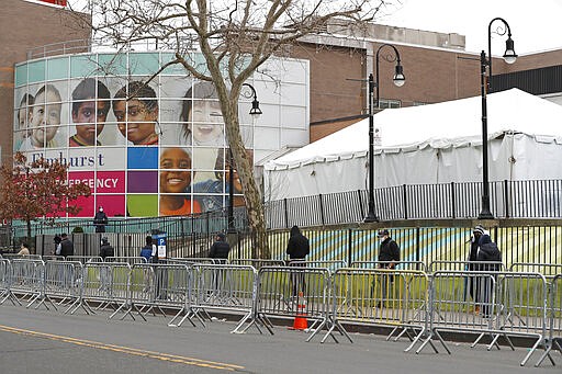 People waiting to be tested for COVID-19 line up with plenty of distance between themselves at Elmhurst Hospital Center in New York, Saturday, March 28, 2020. The hospital is caring for a high number of coronavirus patients in the city. (AP Photo/Kathy Willens)