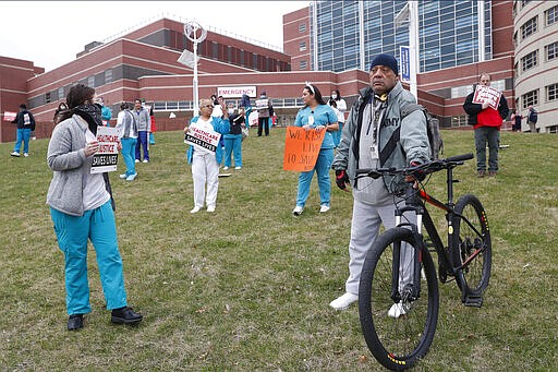 Nurses at Jacobi Medical Center in the Bronx borough of New York gather in front of the emergency room entrance to the hospital, Saturday, March 28, 2020, to demand adequate supplies of personal protective equipment in order to safely treat coronavirus patients. New York leads the nation in the highest number of cases of COVID-19. (AP Photo/Kathy Willens)