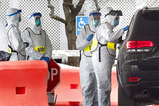 A medical worker takes a sample from a patient inside a car at a special COVID-19 testing site in Boston, Saturday, March 28, 2020. The drive-thru testing site is only open to qualified first responders who meet the state criteria for testing. The new coronavirus causes mild or moderate symptoms for most people, but for some, especially older adults and people with existing health problems, it can cause more severe illness or death. (AP Photo/Michael Dwyer)