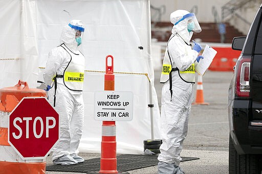 Medical personnel screen people arriving at a special COVID-19 testing site in Boston, Saturday, March 28, 2020. The drive-thru testing site is only open to qualified first responders who meet the state criteria for testing. The new coronavirus causes mild or moderate symptoms for most people, but for some, especially older adults and people with existing health problems, it can cause more severe illness or death. (AP Photo/Michael Dwyer)