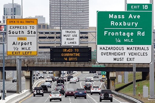 A sign on Interstate 93 in Boston urges out-of-state travelers arriving in Massachusetts to self-quarantine for 14 days, Saturday, March 28, 2020. The new coronavirus causes mild or moderate symptoms for most people, but for some, especially older adults and people with existing health problems, it can cause more severe illness or death. (AP Photo/Michael Dwyer)