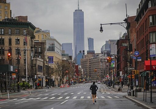 A lone jogger run on a partially empty 7th Avenue, resulting from citywide restrictions calling for people to stay indoors and maintain social distancing in an effort to curb the spread of COVID-19, Saturday March 28, 2020, in New York. President Donald Trump says he's considering a quarantine affecting residents of the state and neighboring New Jersey and Connecticut amid the coronavirus outbreak, but&#160;New York Gov. Andrew Cuomo said that roping off states would amount to &quot;a federal declaration of war.&quot; (AP Photo/Bebeto Matthews)