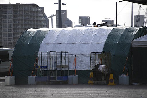 Ambulances and camp tents are seen outside the Excel in London, Saturday, March 28, 2020.The British Government announced Tuesday, that the ExCel Center in east London will become a 4,000 bed temporary hospital to deal with future coronavirus patients, to be called NHS Nightingale. The new coronavirus causes mild or moderate symptoms for most people, but for some, especially older adults and people with existing health problems, it can cause more severe illness or death.(AP Photo/Alberto Pezzali)