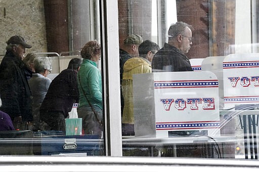 In this Wednesday, March 18, 2020, photo, early voters cast their ballots at the Zeidler Municipal Building in Milwaukee. Wisconsin Legislature's top Republicans told Democratic county clerks on Friday, March 27, to stop telling people they can mark themselves as indefinitely confined to get around photo ID requirements for absentee ballots, saying the governor's stay-at-home order isn't a lockdown. Wisconsin voters can request absentee ballots online, but they must upload a photo ID with the application. Voters who are indefinitely confined are exempt from the photo ID requirement. (AP Photo/Morry Gash)