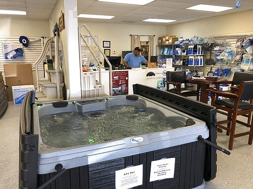 In this March 27, 2020 photo, Aric Strickland works at his business Leisure Life Pools, Spas &amp; Billiards in Lugoff, SC. Strickland said his business should be considered essential if South Carolina's governor gives a stay at home order. (AP Photo/Jeffrey Collins)