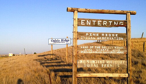 HOLD FOR USE WITH STORY MOVING THURSDAY, MARCH 19,2020-FILE - This Sept. 9, 2012 file photo shows the entrance to the Pine Ridge Indian Reservation in South Dakota, home to the Oglala Sioux tribe. Native American tribes across the U.S. for weeks have been shutting down casinos, hotels and tourist destinations, and shoring up services amid worries that the spread of the coronavirus quickly could overwhelm a chronically underfunded health care system and affect a population that suffers disproportionately from cancer, diabetes and some respiratory diseases. (AP Photo/Kristi Eaton, File)