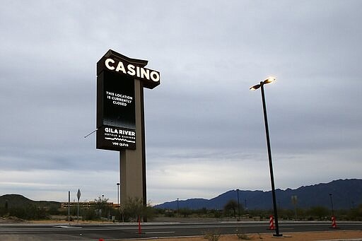 A sign shows the Gila River Hotels &amp; Casinos Vee Quiva location closed due to the coronavirus Friday, March 20, 2020, in Laveen, Ariz. Native American tribes across the U.S. have been closing their properties, with all casinos in the Phoenix metro area closing down. (AP Photo/Ross D. Franklin)