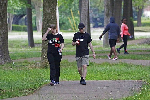 Walkers and runners take advantage of the 1-mile Parham Bridges walking track, Monday, March 23, 2020, in Jackson, Miss. Runners across the country are still hitting the pavement and the trails, staying fit and working off some stress amid the coronavirus pandemic. (AP Photo/Rogelio V. Solis)