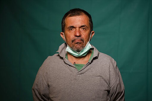 Doctor Sebastiano Petracca, 48, head physician of the ICU at the Rome's COVID 3 Spoke Casalpalocco Clinic poses for a portrait, Friday, March 27, 2020, during a break in his daily shift. Their eyes are tired. Their cheekbones are rubbed raw from protective masks. They don't smile. The intensive care doctors and nurses on the front lines of the coronavirus pandemic in Italy are often almost unrecognizable behind their masks, scrubs, gloves and hairnets their only barrier to contagion. (AP Photo/Domenico Stinellis