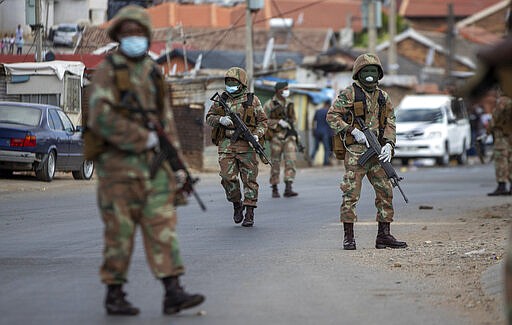 South African National Defence Forces patrol the streets at a densely populated Alexandra township east of Johannesburg, South Africa, Saturday, March 28, 2020. South Africa went into a nationwide lockdown for 21 days in an effort to mitigate the spread to the coronavirus. The new coronavirus causes mild or moderate symptoms for most people, but for some, especially older adults and people with existing health problems, it can cause more severe illness or death. (AP Photo/Themba Hadebe)