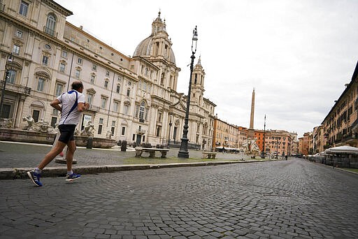 A man runs in Rome's Piazza Navona Square, two and half weeks into a national lockdown to contain the spread of the Covid-19 virus, in Rome, Saturday, March 28, 2020. The new coronavirus causes mild or moderate symptoms for most people, but for some, especially older adults and people with existing health problems, it can cause more severe illness or death. (AP Photo/Andrew Medichini)