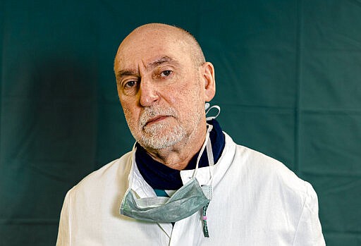 Director of the Intensive Care unit Gabriele Tomasoni, 65, poses for a portrait at the Brescia Spedali Civic Hospital, in Brescia, Italy Friday, March 27, 2020. The intensive care doctors and nurses on the front lines of the coronavirus pandemic in Italy are almost unrecognizable behind their masks, scrubs, gloves and hairnets. &quot;These are patients who are starving for air,&quot; said Tomasoni. &quot;We know these are elderly patients,&quot; Tomasoni said at the end of his shift on Friday evening. &quot;They need closeness. Tenderness.&quot; (AP Photo/Luca Bruno)