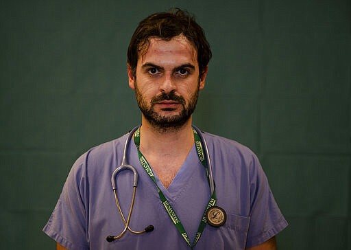 Alessandro D'Aveni, 33, an oncologist working in the COVID sub-intensive care unit at the Humanitas Gavazzeni Hospital in Bergamo, Italy poses for a portrait at the end of his shift Friday, March 27, 2020. (AP Photo/Antonio Calanni)