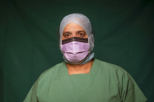 Adriano Rodriguez, 48, an ICU nurse at Rome's COVID 3 Spoke Casalpalocco Clinic poses for a portrait, Friday, March 27, 2020, during a break in his daily shift. (AP Photo/Domenico Stinellis)