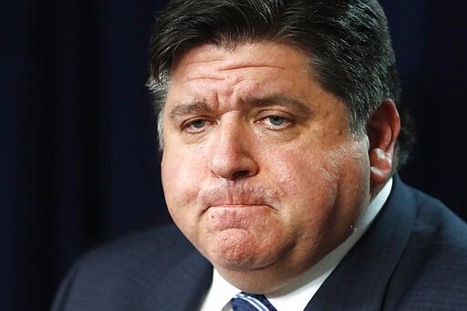 In this March 19, 2020 photo, Illinois Gov. J.B. Pritzker listens to a question during a news conference in Chicago. Amid an unprecedented public health crisis, the nation&#146;s governors are trying to get what they need from the federal government &#8211; and fast. But often that means navigating the disorienting politics of dealing with President Donald Trump. (AP Photo/Charles Rex Arbogast)