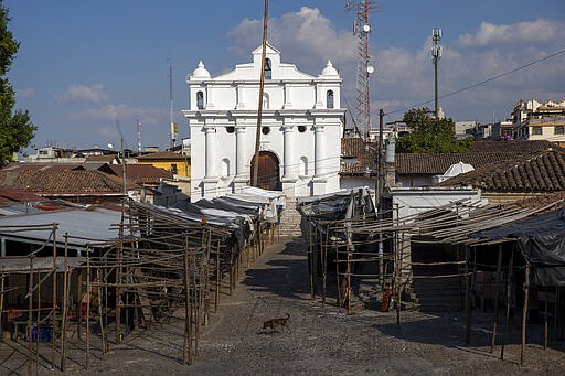 A dog walks in the Chichicastenango artisan and food market empty of shoppers during a stay-at-home curfew across the country to help prevent the spread of the new coronavirus in Santo Tomas Chichicastenango, Guatemala, Saturday, March 28, 2020. Activity at the iconic market has been limited to the sale of food and only for a few hours, in an effort to help prevent the spread of the new coronavirus. (AP Photo/Moises Castillo)