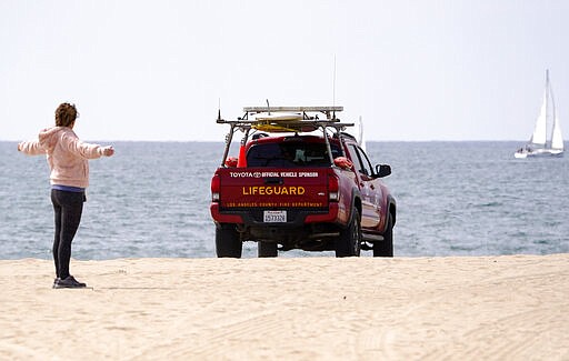 A Los Angeles County lifeguard patrols a sparsely populated Venice Beach, Saturday, March 28, 2020, in Los Angeles. With cases of coronavirus surging and the death toll surpassing 100, lawmakers are pleading with cooped-up Californians to spend a second weekend at home to slow the spread of the infections. It has been more than a week since Gov. Gavin Newsom barred 40 million residents from going outdoors except for essentials. Even so, reports of crowds have prompted local and state officials to warn that ignoring social distancing, park and beach closures could spread the virus, which already is surging. The new coronavirus causes mild or moderate symptoms for most people, but for some, especially older adults and people with existing health problems, it can cause more severe illness or death. (AP Photo/Mark J. Terrill)