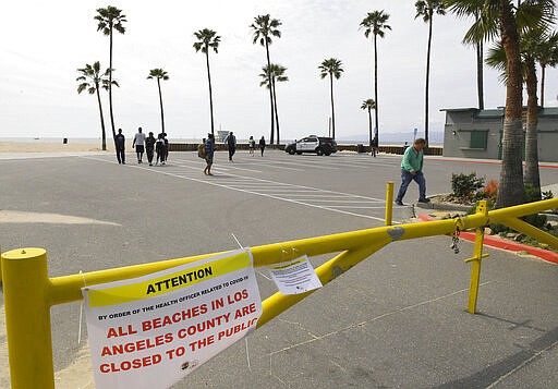 Los Angeles police officers shoo away beachgoers at Venice Beach, Saturday, March 28, 2020, in Los Angeles. With cases of coronavirus surging and the death toll surpassing 100, lawmakers are pleading with cooped-up Californians to spend a second weekend at home to slow the spread of infections. (AP Photo/Mark J. Terrill)