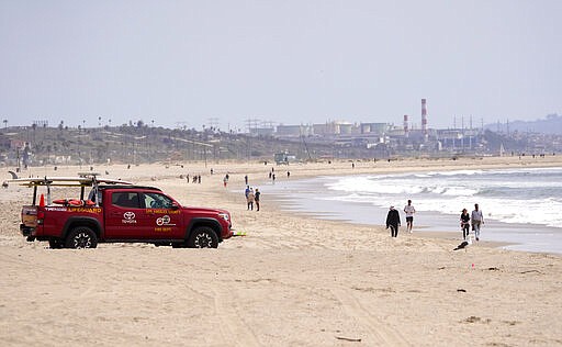 A Los Angeles County lifeguard patrols a sparsely populated Venice Beach, Saturday, March 28, 2020, in Los Angeles. With cases of coronavirus surging and the death toll surpassing 100, lawmakers are pleading with cooped-up Californians to spend a second weekend at home to slow the spread of the infections. It has been more than a week since Gov. Gavin Newsom barred 40 million residents from going outdoors except for essentials. Even so, reports of crowds have prompted local and state officials to warn that ignoring social distancing, park and beach closures could spread the virus, which already is surging. The new coronavirus causes mild or moderate symptoms for most people, but for some, especially older adults and people with existing health problems, it can cause more severe illness or death. (AP Photo/Mark J. Terrill)