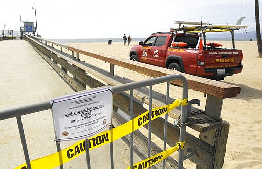 A Los Angeles County lifeguard patrols a sparsely populated Venice Beach, Saturday, March 28, 2020, in Los Angeles. With cases of coronavirus surging and the death toll surpassing 100, lawmakers are pleading with cooped-up Californians to spend a second weekend at home to slow the spread of the infections. It has been more than a week since Gov. Gavin Newsom barred 40 million residents from going outdoors except for essentials. Even so, reports of crowds have prompted local and state officials to warn that ignoring social distancing, park and beach closures could spread the virus, which already is surging. The new coronavirus causes mild or moderate symptoms for most people, but for some, especially older adults and people with existing health problems, it can cause more severe illness or death. (AP Photo/Mark J. Terrill)