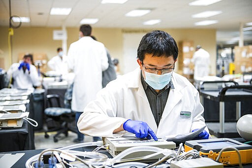 James Nguyen, a fuel cell stack testing engineer, tests ventilator oxygen at Bloom Energy in Sunnyvale, Calif., Saturday, March 28, 2020. Bloom Energy is a fuel cell generator company that has switched over to refurbishing ventilators as an increasing number of patients experience respiratory issues as a result of COVID-19.. (Beth LaBerge/Pool Photo via AP)