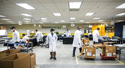 Staff work in a ventilator-refurbishing assembly line at Bloom Energy in Sunnyvale, Calif., Saturday, March 28, 2020. Bloom Energy is a fuel cell generator company that has switched over to refurbishing ventilators as an increasing number of patients experience respiratory issues as a result of COVID-19. (Beth LaBerge/KQED via AP, Pool)