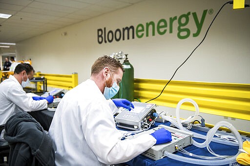 Alex Hawks, a biomedical technician with Cure Biomedical, tests ventilator functionality at Bloom Energy in Sunnyvale, Calif., Saturday, March 28, 2020. Bloom Energy is a fuel cell generator company that has switched over to refurbishing ventilators as an increasing number of patients experience respiratory issues as a result of COVID-19. (Beth LaBerge/Pool Photo via AP)