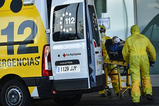 Staff health medical ambulances wearing special equipment to prevent the spread of coronavirus COVID-19 arriving with a patient at San Pedro hospital, in Logrono, northern Spain, Saturday, March 28, 2020.  The new coronavirus causes mild or moderate symptoms for most people, but for some, especially older adults and people with existing health problems, it can cause more severe illness or death. AP Photo/Alvaro Barrientos)