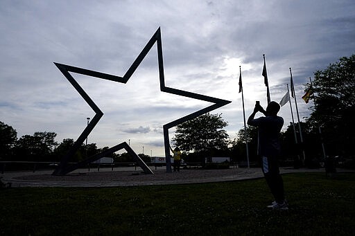 Gus Davis, right, takes a photograph of his wife, Mia, at a rest stop, Sunday, March 29, 2020, in Orange, Texas, near the Louisiana border. The couple is moving from Washington, D.C. to San Antonio. Texas is ratcheting up restrictions on neighboring Louisiana, one of the growing hot spots for the new coronavirus in the U.S. Just two days after Texas began requiring airline passengers from New Orleans to comply with a two-week quarantine, Texas Gov. Greg Abbott said state troopers will now also patrol highway entry points at the Louisiana border. (AP Photo/David J. Phillip)