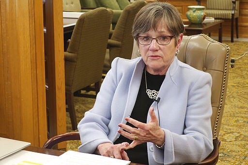 Kansas Gov. Laura Kelly answers questions about attempting to check the spread of the new coronavirus during an interview with The Associated Press in her office, Wednesday, March 25, 2020, at the Statehouse in Topeka, Kan. Kelly says the federal government should force industries to manufacture medical supplies to address a shortage of ventilators, protective masks and testing kits. (AP Photo/John Hanna)